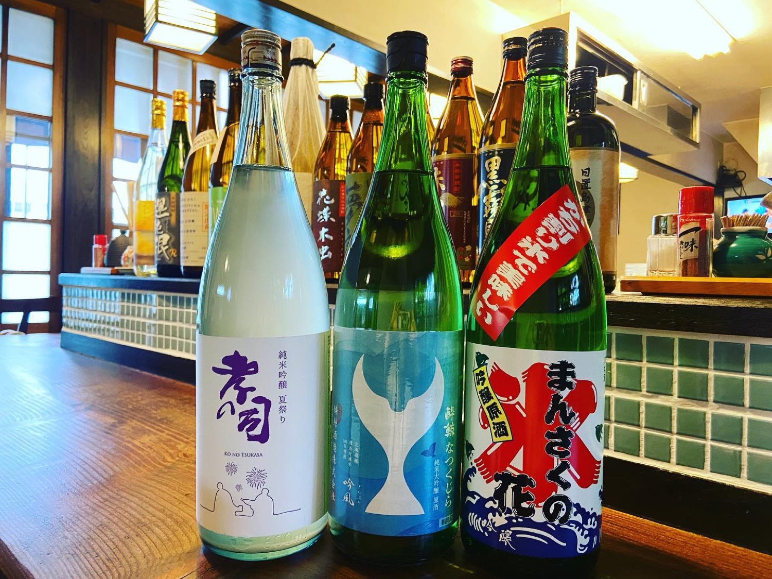 カウンターに並んだその日の日本酒。孝の司、酔鯨、まんさくの花